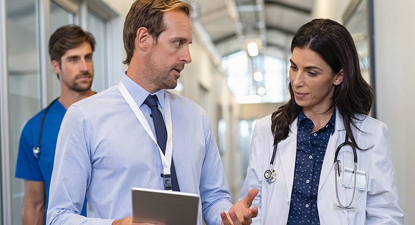 Man in a blue shirt speaking with a doctor