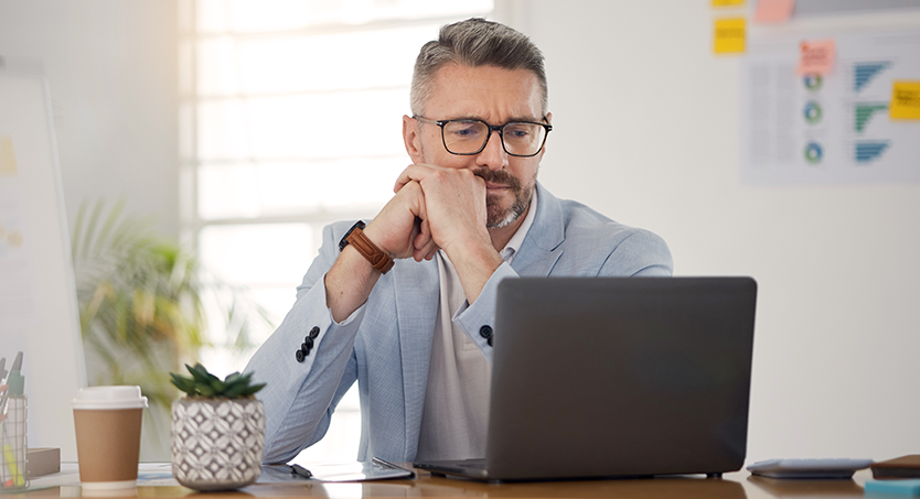 HEDIS Digital Transition - Man reading a document on a laptop