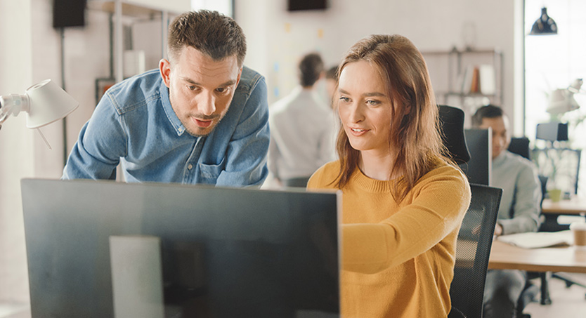 Man and woman working in front of a monitor